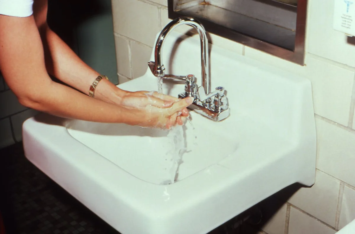 Hands using lever faucet showing ease of use for aging in place
